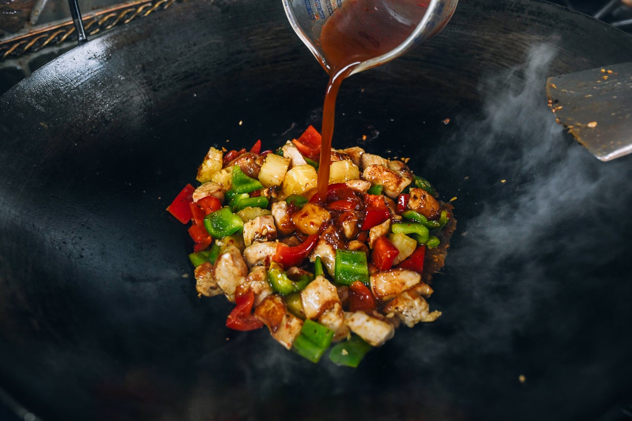 adding sauce mixture to chicken and pineapple