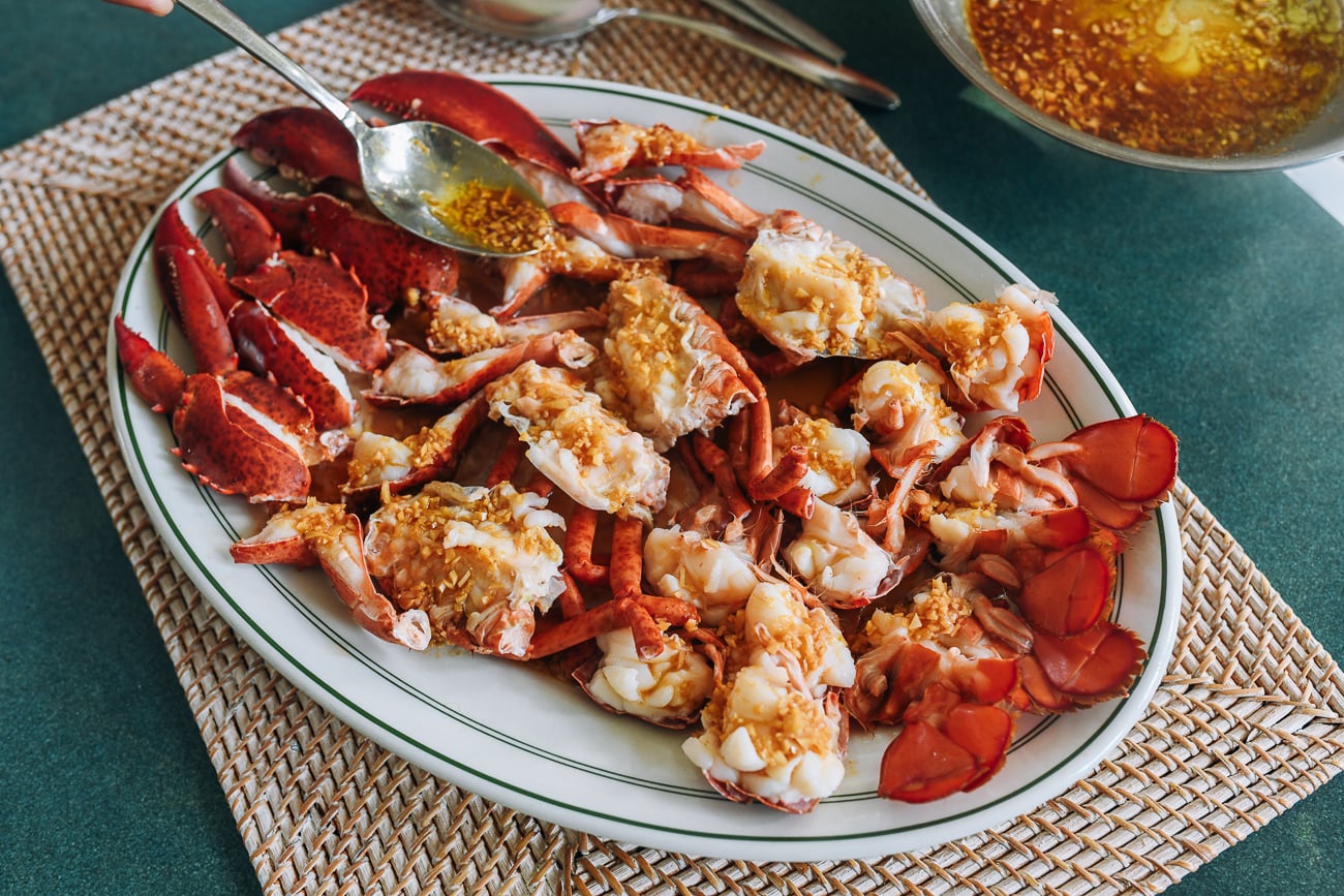 spooning soy garlic butter over steamed lobster