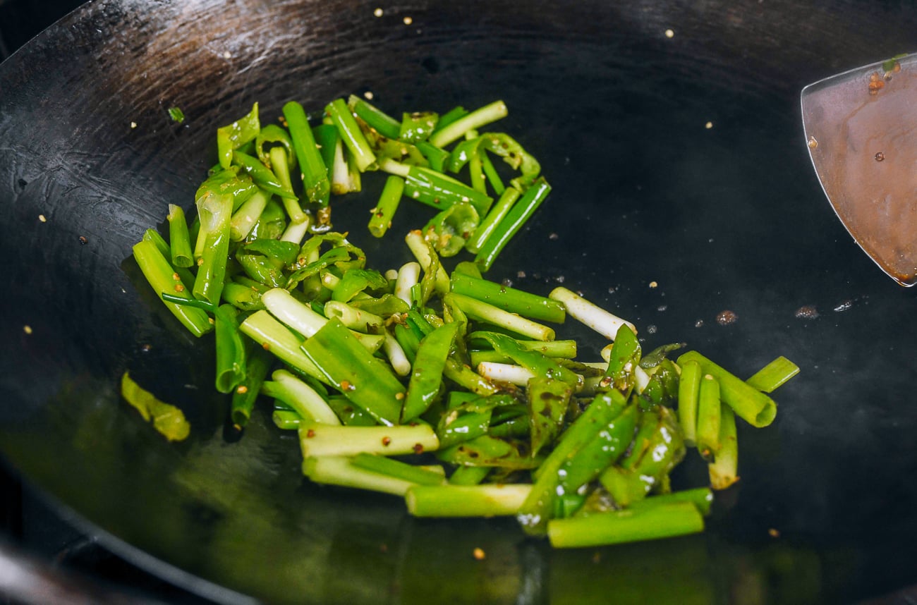 stir-frying scallions and peppers